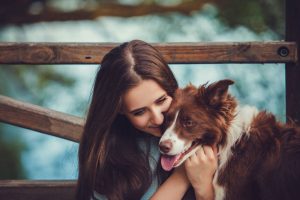 Portrait of a woman with her border collie dog outdoors